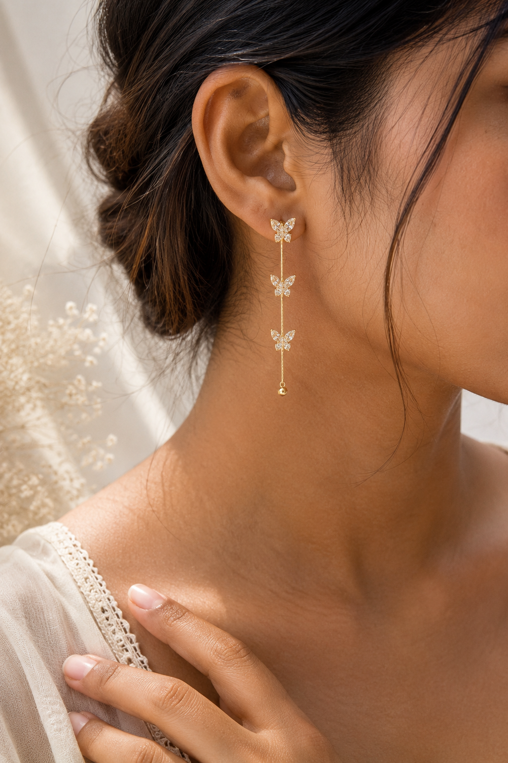 Butterfly Whisper Earrings worn on the ear, three crystal butterflies on fine chains
